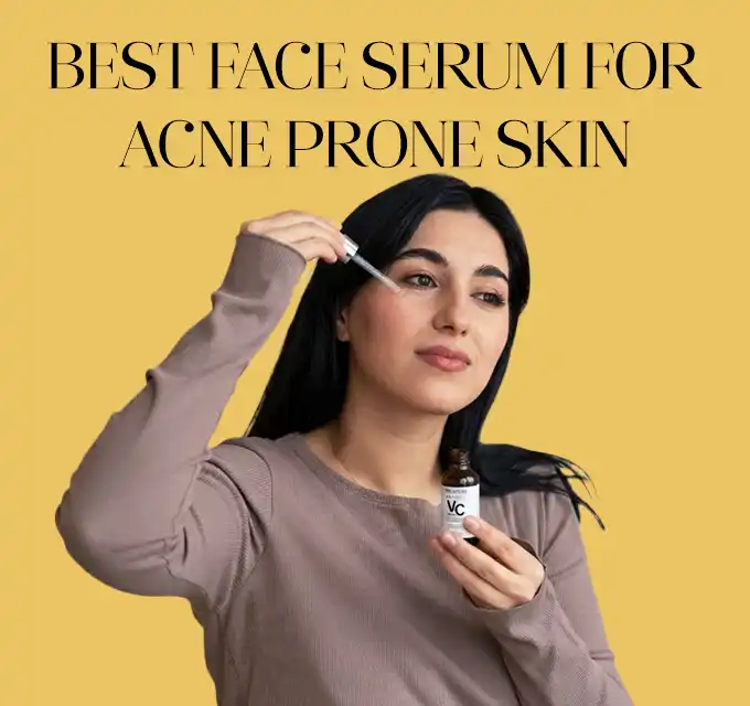 best face serum for acne prone skin Alt text: Woman applying a few drops of clear serum to her forehead from a dropper while holding the bottle, neutral expression, yellow background